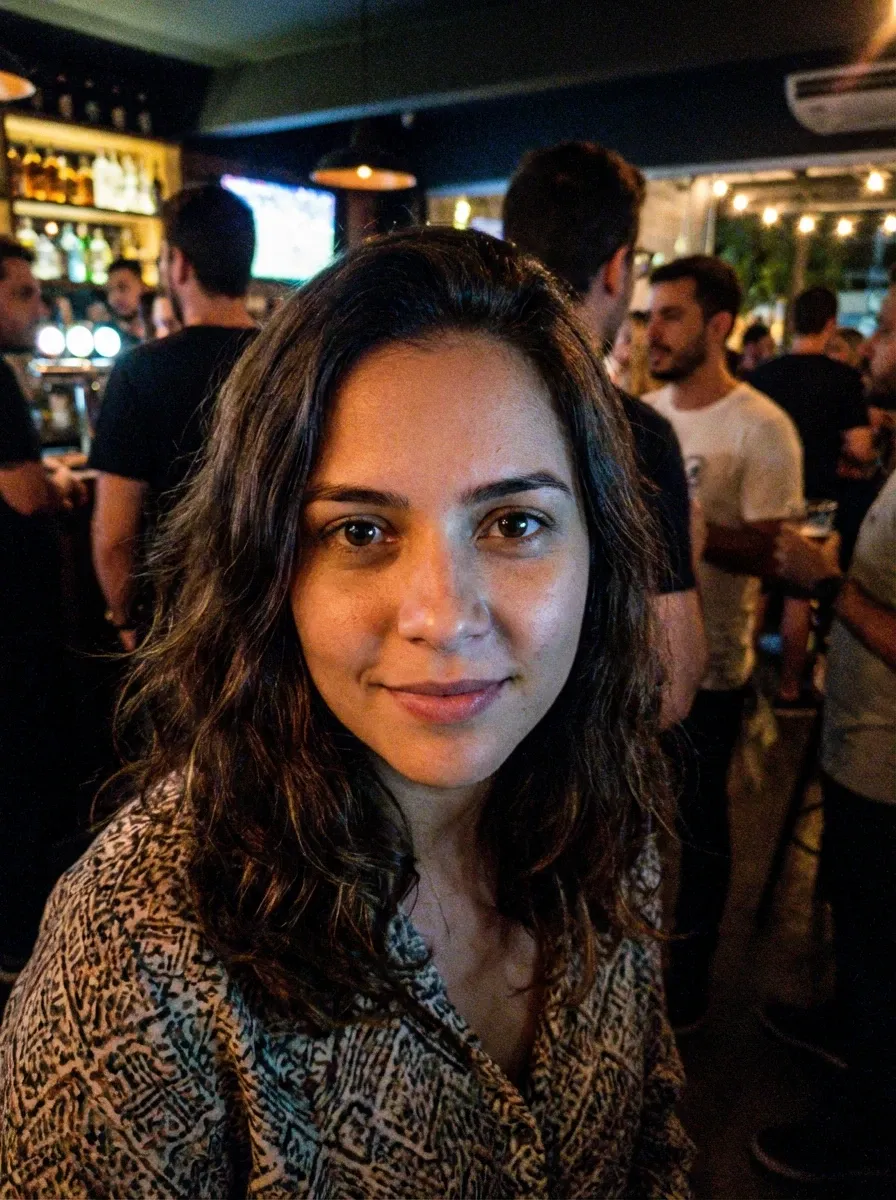 Original selfie input — woman in a patterned top in low light
